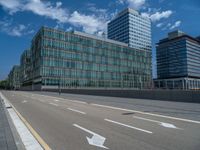 empty road leading to building on cloudy day with sign showing right way and two arrows pointing left