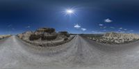 two identical panoramic photographs of a wide view of a canyon, mountains and sand