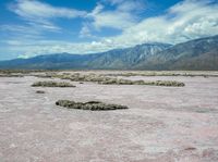 the landscape is almost completely barren and looks like pink sand, so there are some white clouds