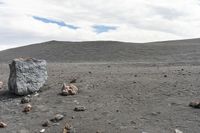 rocks are set out in a barren land, with a lone stone block on the ground