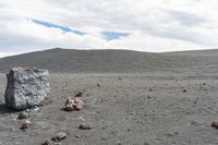 rocks are set out in a barren land, with a lone stone block on the ground