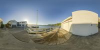 a fisheye image of the beach with its pool and dock, including a boat