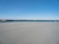 a sandy beach with an overpass that extends from the ocean onto the water in front of it