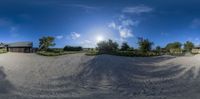 this is a fisheye image of a beach house with the house in the distance