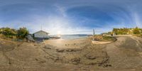 there is a fish - eye view of a small beach and a house on the shore