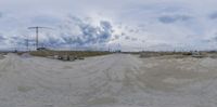 a panorama fisheye view of a beach with an open area in the background and an island