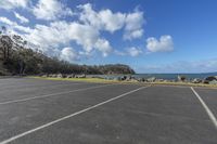 a parking lot with a beach and blue sky in the background on a sunny day