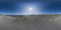 there is a view of the sun in a parking lot at the beach through a fish eye lens