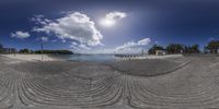 a fisheye image showing the landscape on this beach location of a pier and water