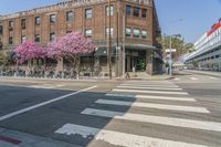 the sidewalk and parking is covered with a lot of trees and flowers in the middle of a city street