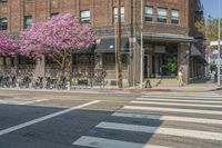 the sidewalk and parking is covered with a lot of trees and flowers in the middle of a city street