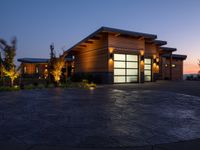 a home in the country side at sunset with modern lighting on and on the ground