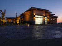 a home in the country side at sunset with modern lighting on and on the ground