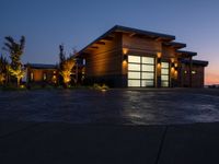 a home in the country side at sunset with modern lighting on and on the ground