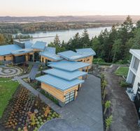 a residential with large windows on a beautiful day looking at a lake and mountains in the distance