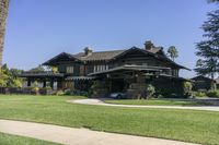 a large brown house with many windows on the outside of it and a car parked in front of it