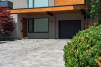 a beautiful house with lots of windows on it and a lot of bushes surrounding the entrance