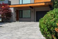 a beautiful house with lots of windows on it and a lot of bushes surrounding the entrance