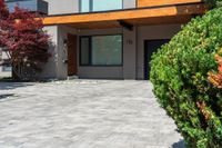 a beautiful house with lots of windows on it and a lot of bushes surrounding the entrance