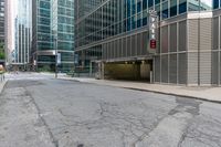 an empty street has many glass buildings next to it in this big city area there is a building on the corner that's on the left side