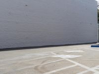 the skateboarder is riding on the cement ramp with no wheels parked nearby at the beginning of his turn