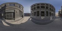 two 360 degrees fisheye images of the corner of a city street with cars parked in front of it