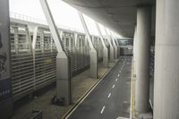 the view of the airport from an above floor area looking into a long walkway next to a parked cars and buildings