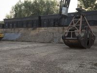 a truck is in a construction area with a machine nearby and a bus in the background