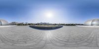 360 - view photograph of cityscape in background and buildings behind area of circular stone structure