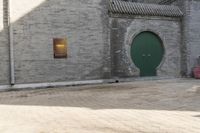the person is walking down the street near old buildings on a sunny day with a red umbrella