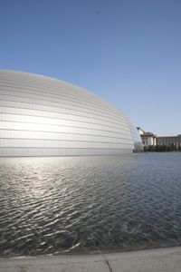 a person on a skateboard in front of a big building with a curved roof