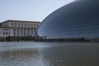 a person on a skateboard in front of a big building with a curved roof