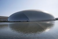 a person on a skateboard in front of a big building with a curved roof