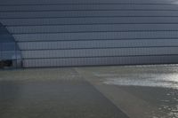 a person on a skateboard in front of a big building with a curved roof