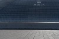 a person on a skateboard in front of a big building with a curved roof