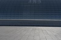 a person on a skateboard in front of a big building with a curved roof