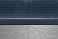 a person on a skateboard in front of a big building with a curved roof