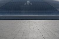 a person on a skateboard in front of a big building with a curved roof