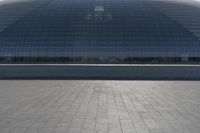 a person on a skateboard in front of a big building with a curved roof