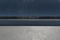 a person on a skateboard in front of a big building with a curved roof