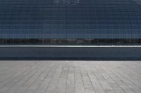 a person on a skateboard in front of a big building with a curved roof