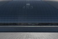 a person on a skateboard in front of a big building with a curved roof