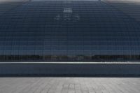 a person on a skateboard in front of a big building with a curved roof