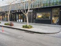 empty sidewalk with no cars on it, in front of the building with many windows
