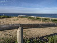 a bench sitting near a fence near the ocean in californian country style by the beach