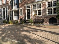 benches near a red brick building in a town square setting with trees, foliage and sunlight