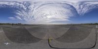 a mirror view of an airfield with blue skies and white clouds around it with a person in the air