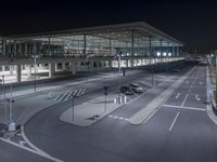 a night view of the airport from above an empty parking lot with vehicles and cars
