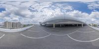 a panoramic view of a road in an airport with some buildings and a sky