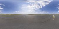 an airport runway that has several curves on it with clouds above it in the background